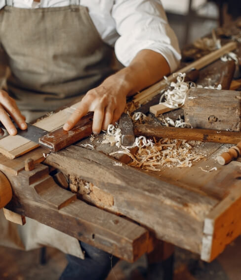Wooden craftsman working with a plank.